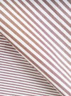 Close-up fabric detail of the brown Queens cotton patched shirt, showing a woven stripe pattern in alternating brown and white. The fabric is folded to reveal both the outer surface and an inner layer with narrower stripes, highlighting the cotton weave texture.
