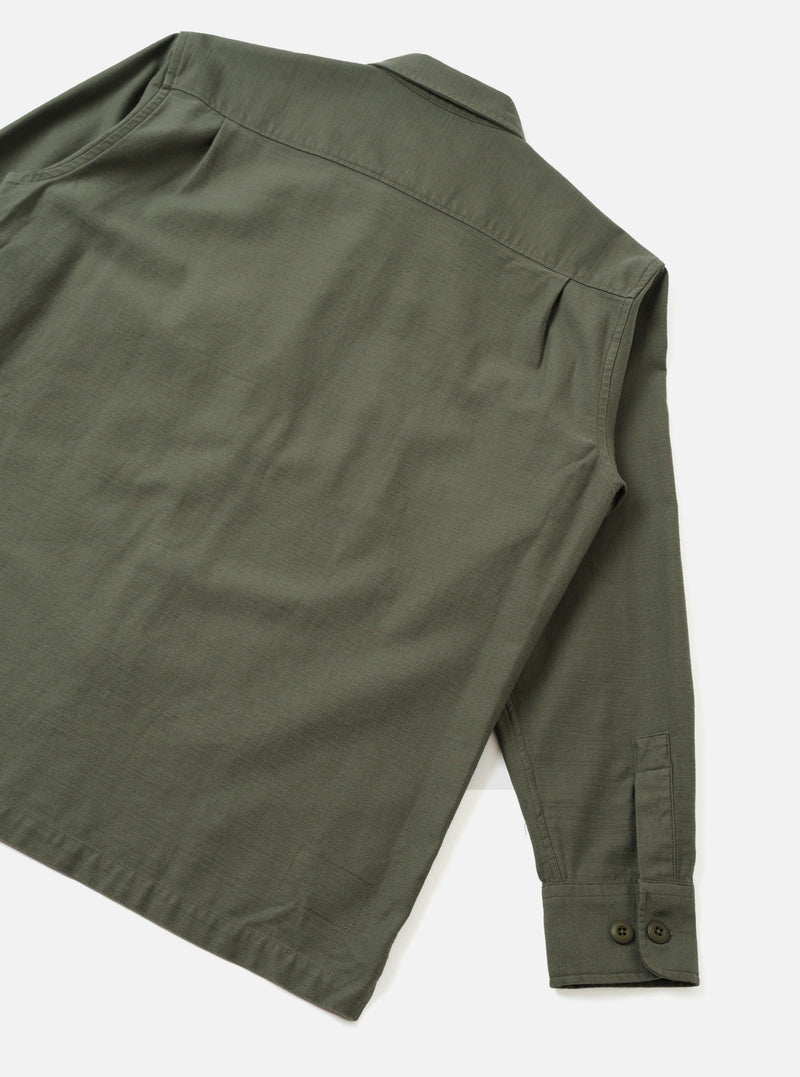 Back view of the Olive Slub Sateen Fatigue Shirt presented against a clean off-white background. The image details the rear shoulder yoke, straight hemline, and durable olive fabric construction.