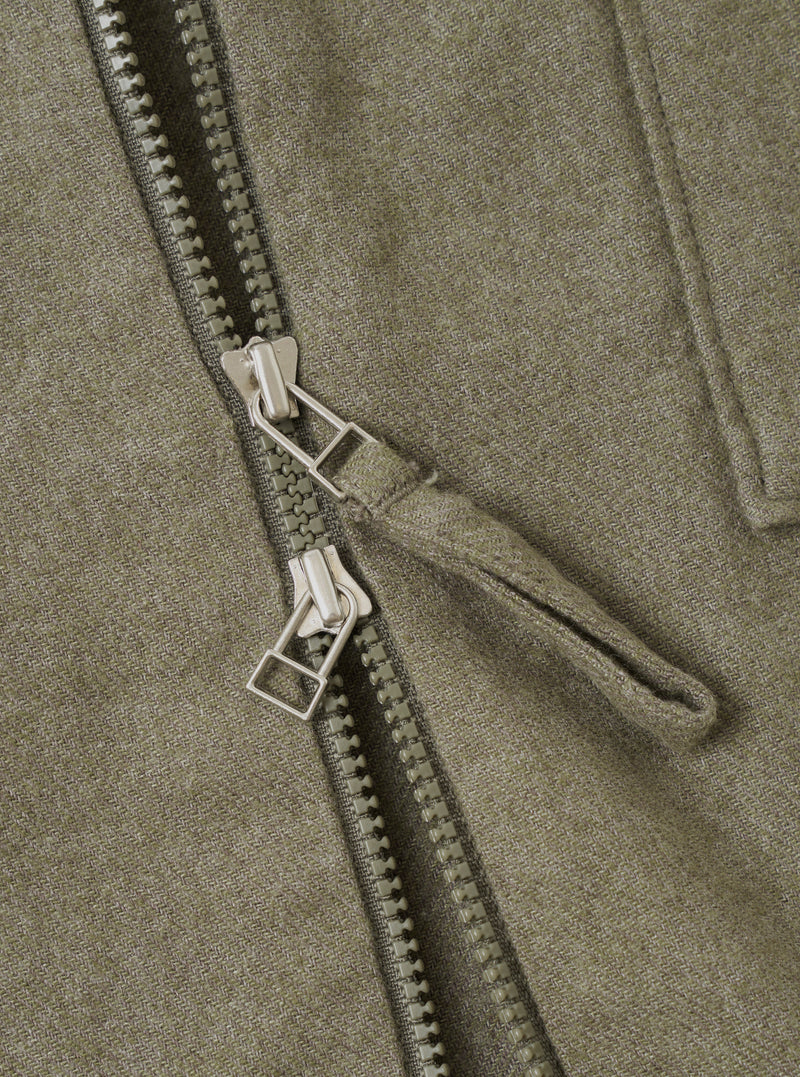 A detailed close-up view of the Olive Monty Cotton Tencel Zip Shirt on a plain white studio background, emphasizing the front zip fastening, collar stitching, and textured fabric weave.