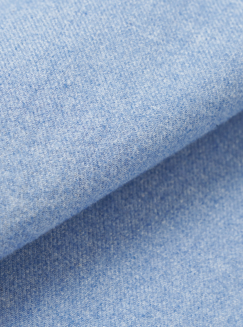 A full-frame fabric swatch closeup displaying the subtle weave pattern, soft cotton-tencel texture, and sky blue color of the material from the Sky Blue Monty Cotton Tencel Zip Shirt.