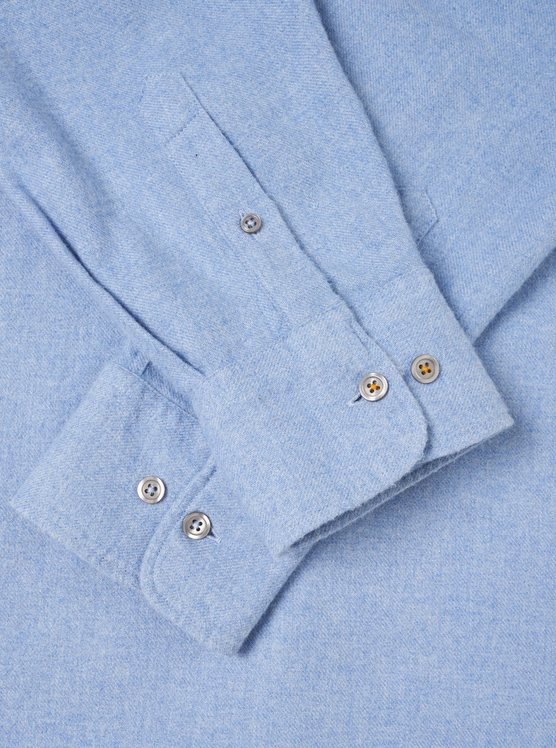 A back view of the Sky Blue Monty Cotton Tencel Standard Shirt presented against a clean off-white background. The shot highlights the smooth back panel, shoulder yoke, neat hemline, and light blue fabric texture.