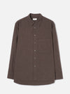 Brown brushed flannel shirt on a plain light grey studio backdrop, no model or mannequin. Features a point collar, five-button placket with dark buttons, one large patch pocket on the left chest, long sleeves with plain cuffs, and a curved hem. The fabric has a soft, matte flannel texture in a muted brown marl.