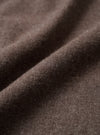 Close-up detail shot of the brown brushed flannel fabric used in the square pocket shirt. The textile shows a soft, lightly napped surface with fine fibres visible across the weave. The cloth is folded to reveal its drape and depth of colour, a warm muted brown with subtle grey undertones.
