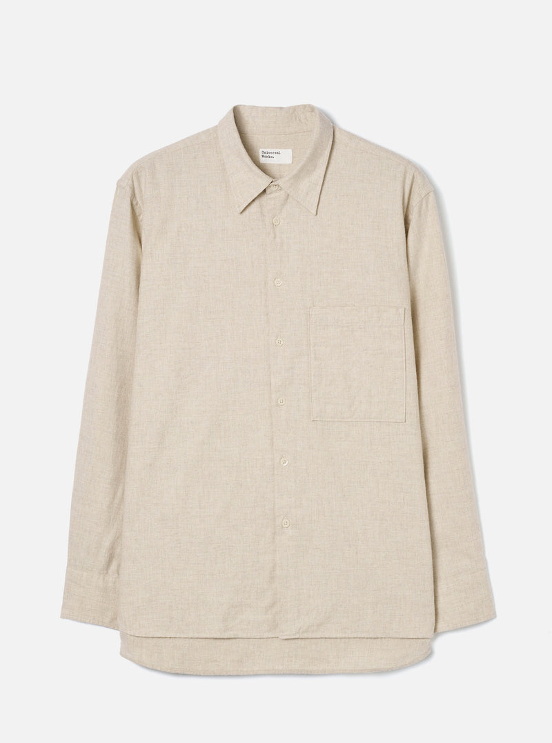 Ecru brushed flannel long-sleeve shirt laid flat on a light grey studio backdrop. Features a point collar, full button placket with tonal buttons, a single patch chest pocket on the left, buttoned cuffs, and a curved shirttail hem. The fabric has a soft, lightly textured flannel weave. A Universal Works woven label sits at the back collar.