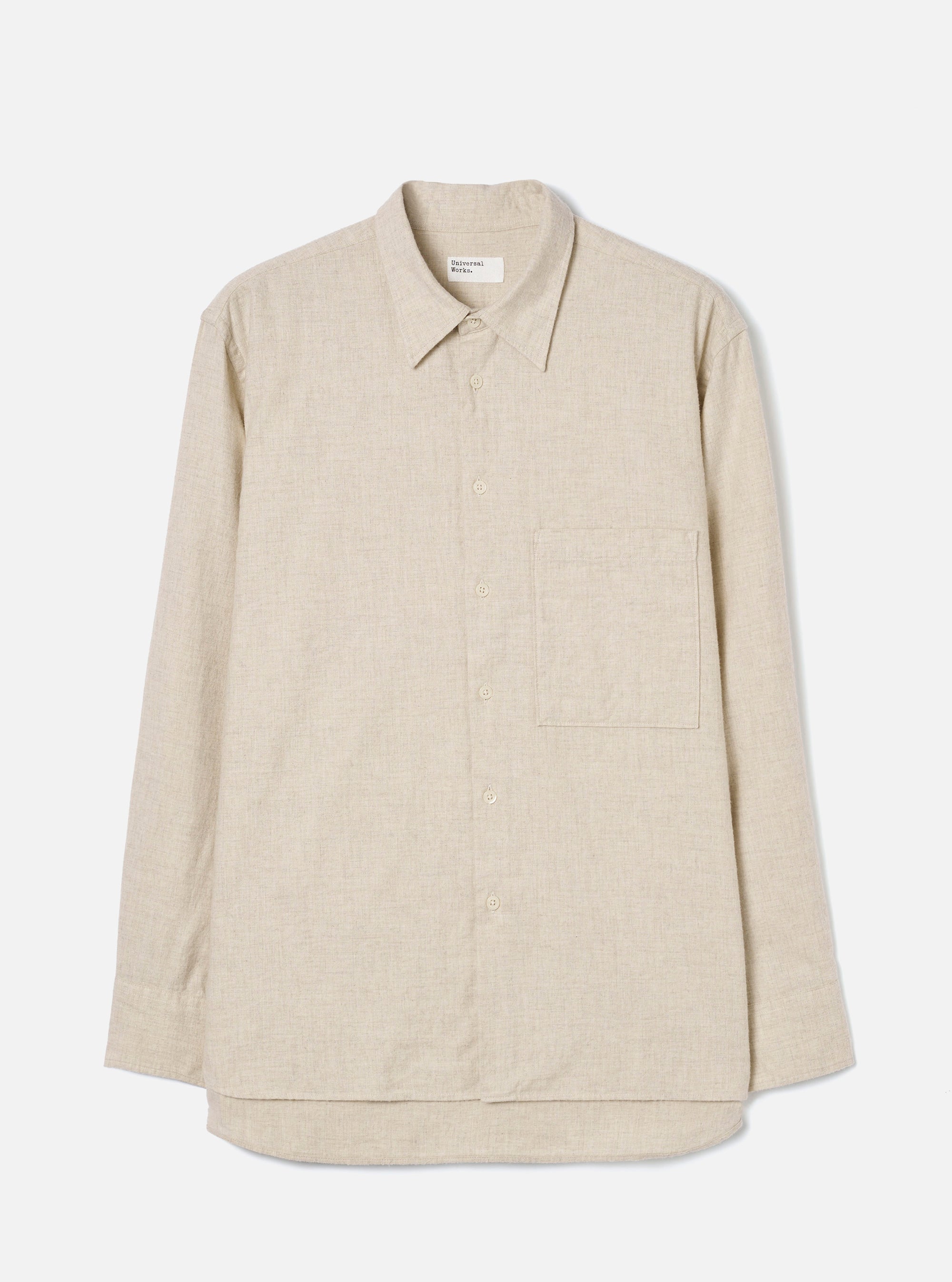 Ecru brushed flannel long-sleeve shirt laid flat on a light grey studio backdrop. Features a point collar, full button placket with tonal buttons, a single patch chest pocket on the left, buttoned cuffs, and a curved shirttail hem. The fabric has a soft, lightly textured flannel weave. A Universal Works woven label sits at the back collar.
