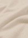 Close-up of the ecru brushed flannel fabric, showing soft, lightly napped texture with gentle folds and a warm off-white tone. Fine knit fibres are visible across the surface. No garment details or background are visible in this detail shot.