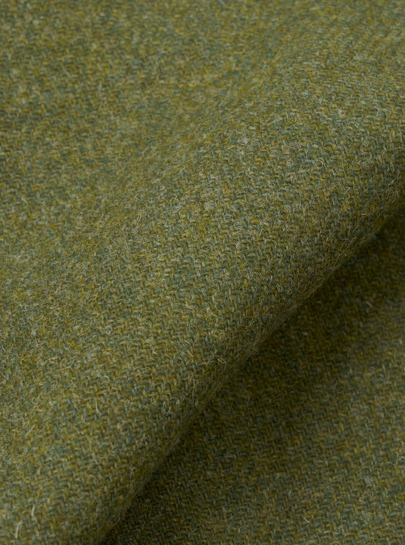 A detailed close-up swatch image showing the material structure of the Olive Harris Tweed Easy Jacket. The frame is filled with the green olive tweed weave, displaying thread variations and quality.