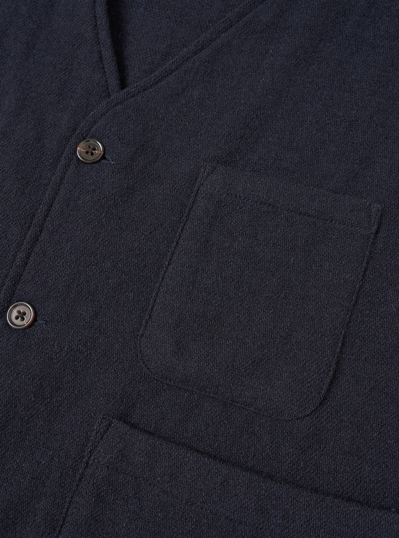 A male model wears the Dark Navy Robin Wool Mix JJ Waistcoat buttoned up over a shirt, standing against a neutral studio backdrop to show the relaxed tailoring and comfortable fit.