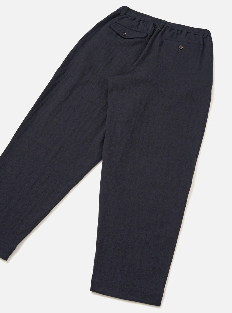 Rear view of the Dark Navy Robin Wool Mix Pleated Track Pant set against a plain off-white background. The shot highlights the relaxed fit, back welt pockets, and clean hem construction.
