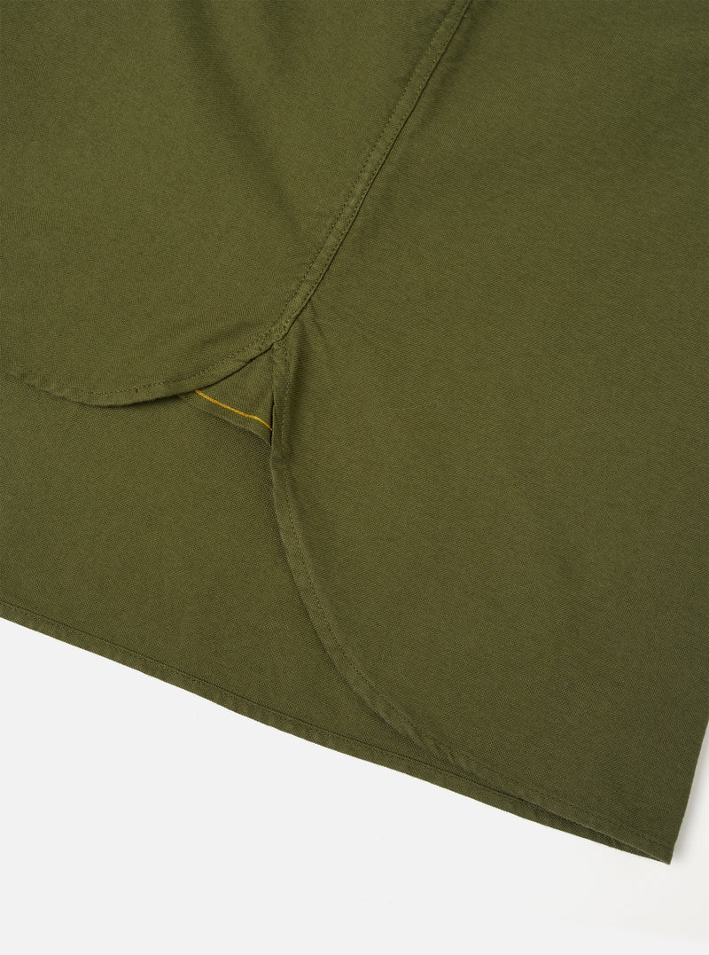 A detailed close-up shot of the Olive R.Oxford Lazy Day Shirt, showing the asymmetric chest pocket, neat stitching, and button-down collar against a plain studio background.