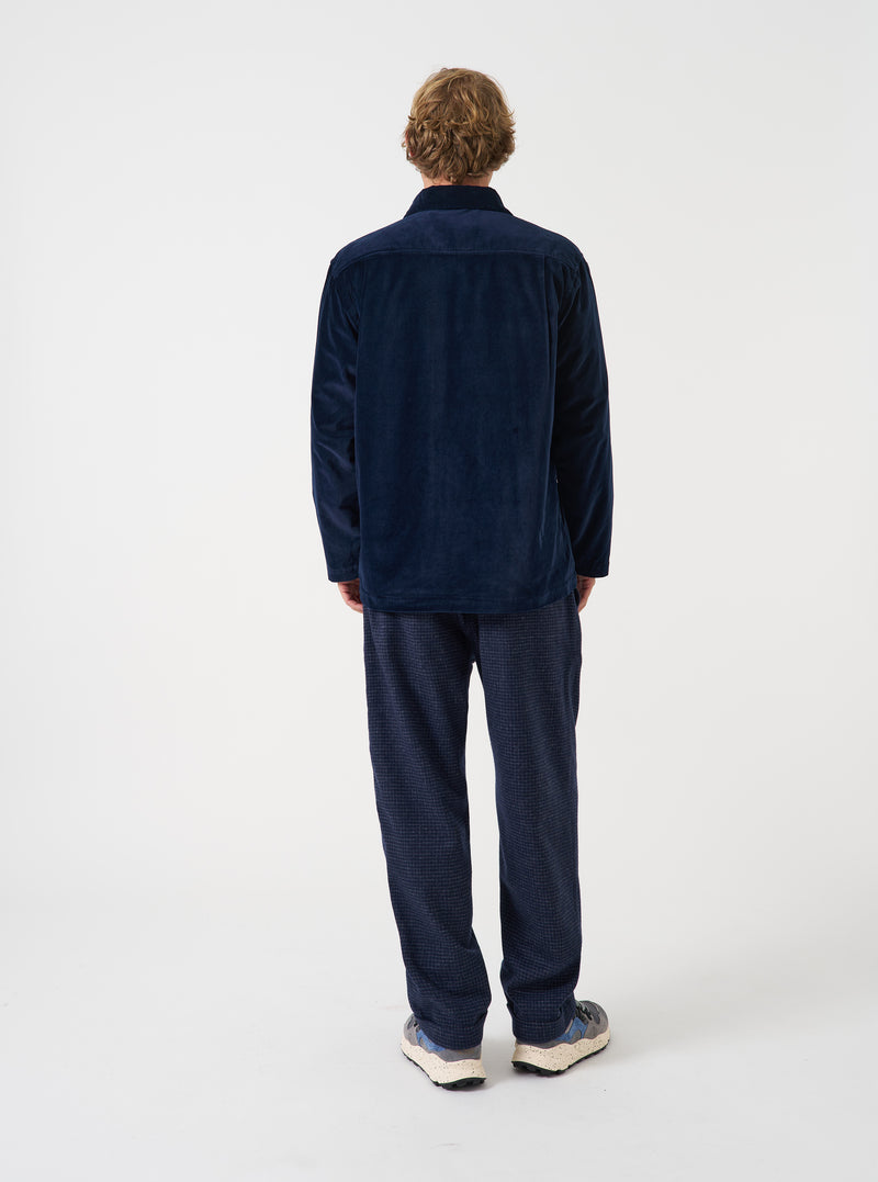 A male model wears the Navy CPH Velvet Dockside overshirt unbuttoned in a side-profile view against a plain studio background. The image details the soft collar, rich navy velvet texture, and comfortable silhouette.