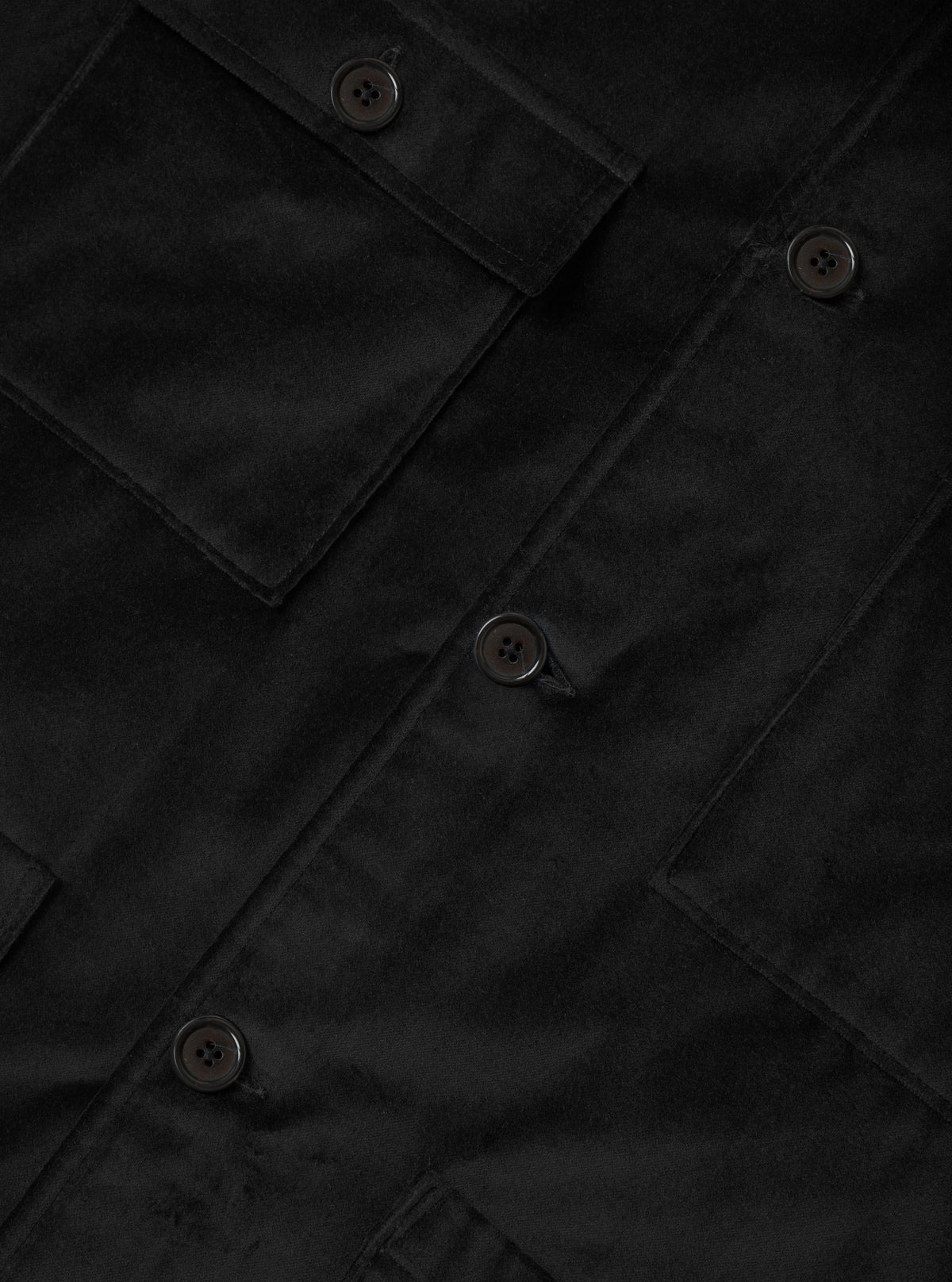 Close-up detail of the Black CPH Velvet Dockside, showing the button placket with four-hole dark buttons and a chest patch pocket with a buttoned flap. The fabric has a rich velvet texture with a soft, matte finish. No model or mannequin visible.