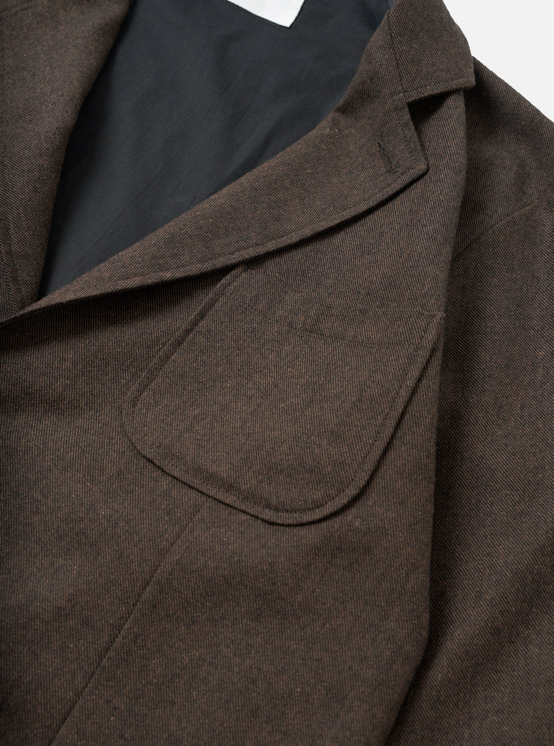 An angled view of the Brown Recycled Italian Tweed Two Button Jacket on a plain off-white backdrop. The photo details the lapel construction, sleeve tailoring, and subtle woven texture of the recycled wool blend fabric.