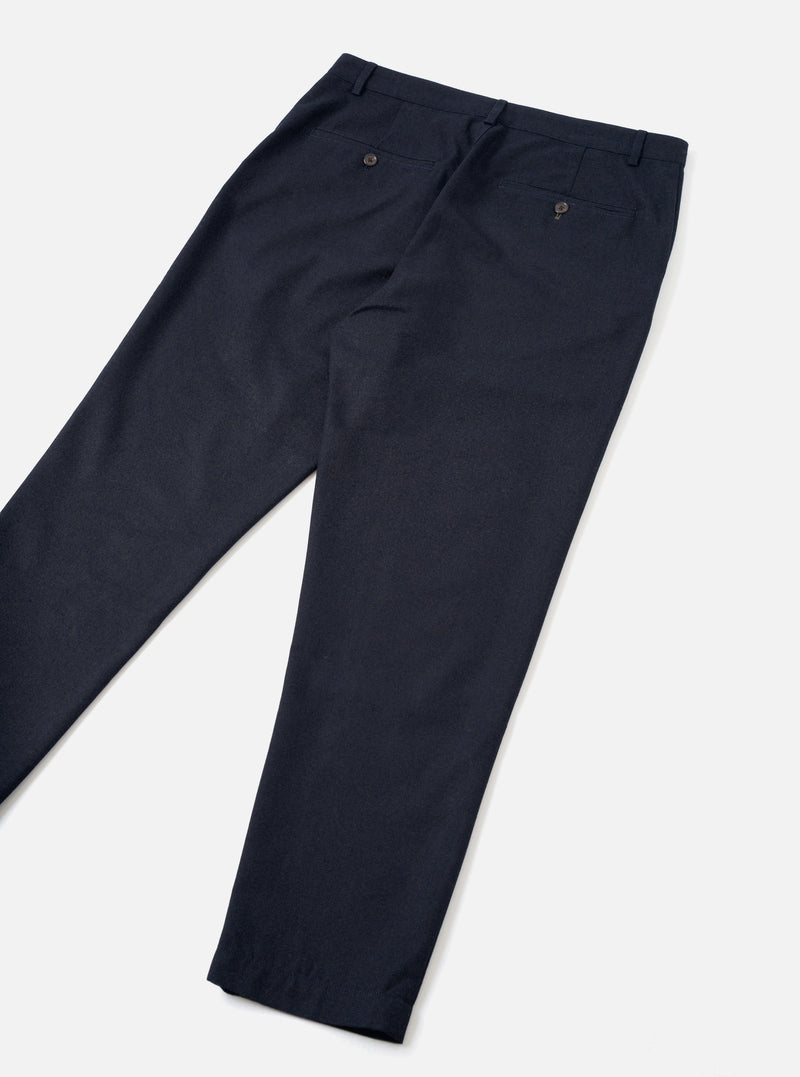 A back view of a model wearing the Navy Recycled Italian Tweed Military Chino against a neutral studio backdrop. The shot highlights the rear pockets, tailored seam details, and structured navy blue tweed material.