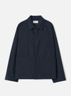 A front view of a model wearing the Navy Lucca Suiting Ives Jacket against a neutral studio backdrop. The photograph showcases the jacket's relaxed fit, button front closure, collar, and classic patch pockets in navy blue.