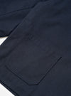 A close-up detailed view of a model wearing the Navy Lucca Suiting Ives Jacket in a studio setting, focusing on the buttoned front placket, collar construction, and texture of the dark navy suiting fabric.