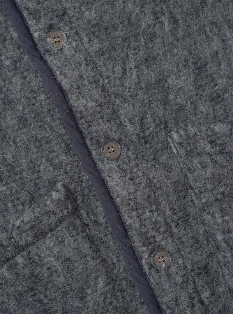 A close-up photograph of a model wearing the Navy/Pale Grey Losso Mohair Mix Lancaster Gilet, focusing on the collar, button closures, patch pocket detail, and fuzzy navy and pale grey mohair blend knit texture.