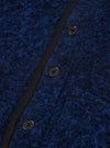 Close-up detail of the blue boucle style fleece Lancaster jacket, showing three dark four-hole buttons fastened along a narrow black grosgrain placket trim. The boucle style texture is prominent, with a dense, looped navy and blue marl surface. Shot against a plain white studio backdrop.