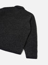 Charcoal boucle style fleece Lancaster jacket shot flat on a plain light grey backdrop. The rear three-quarter view shows the textured boucle style fabric across the back and one sleeve, with contrast black ribbed trim at the cuff and hem. A black collar is visible at the top neckline.