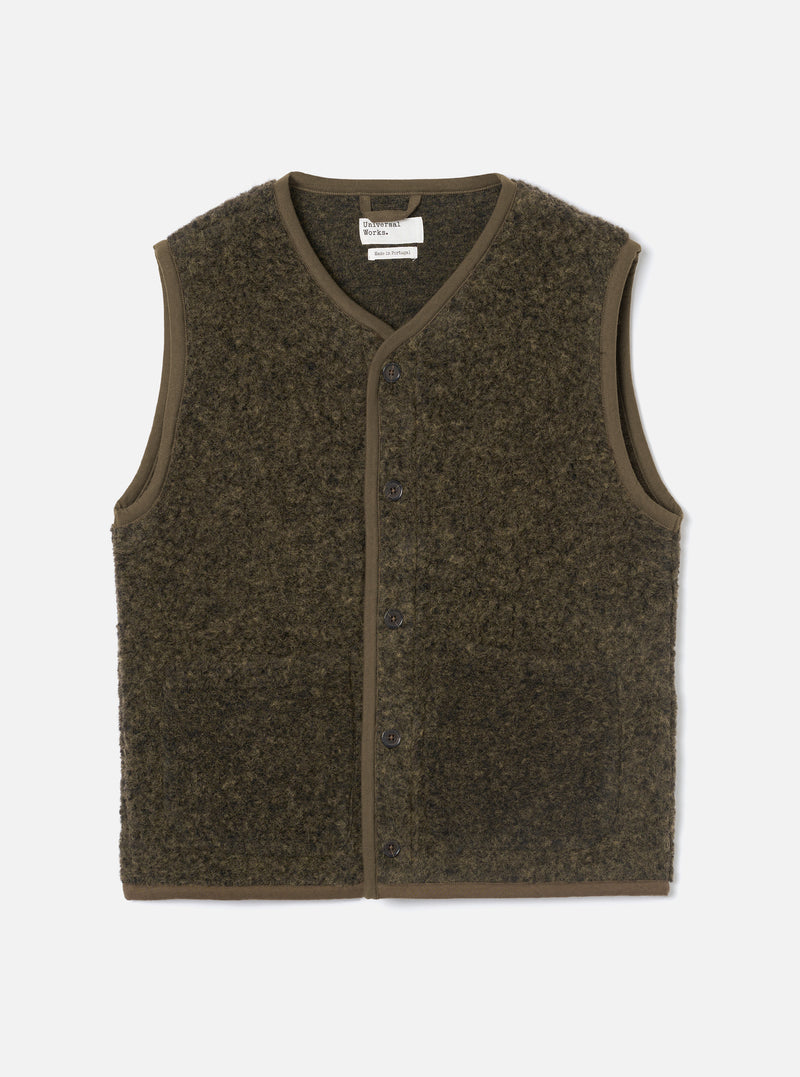 Brown boucle style fleece gilet laid flat on a light grey studio backdrop. V-neckline with brown binding trim running around the neck, armholes and hem. Six dark buttons fasten the centre front placket. Universal Works woven label visible at the neck. Textured, looped fleece fabric throughout.