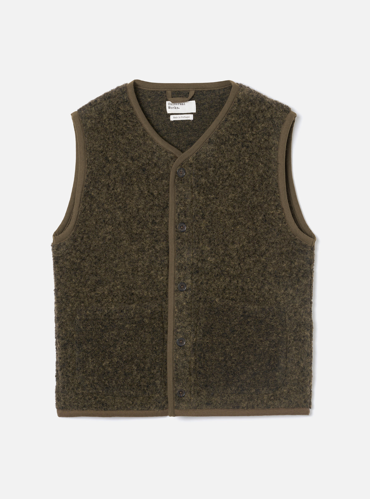 Brown boucle style fleece gilet laid flat on a light grey studio backdrop. V-neckline with brown binding trim running around the neck, armholes and hem. Six dark buttons fasten the centre front placket. Universal Works woven label visible at the neck. Textured, looped fleece fabric throughout.