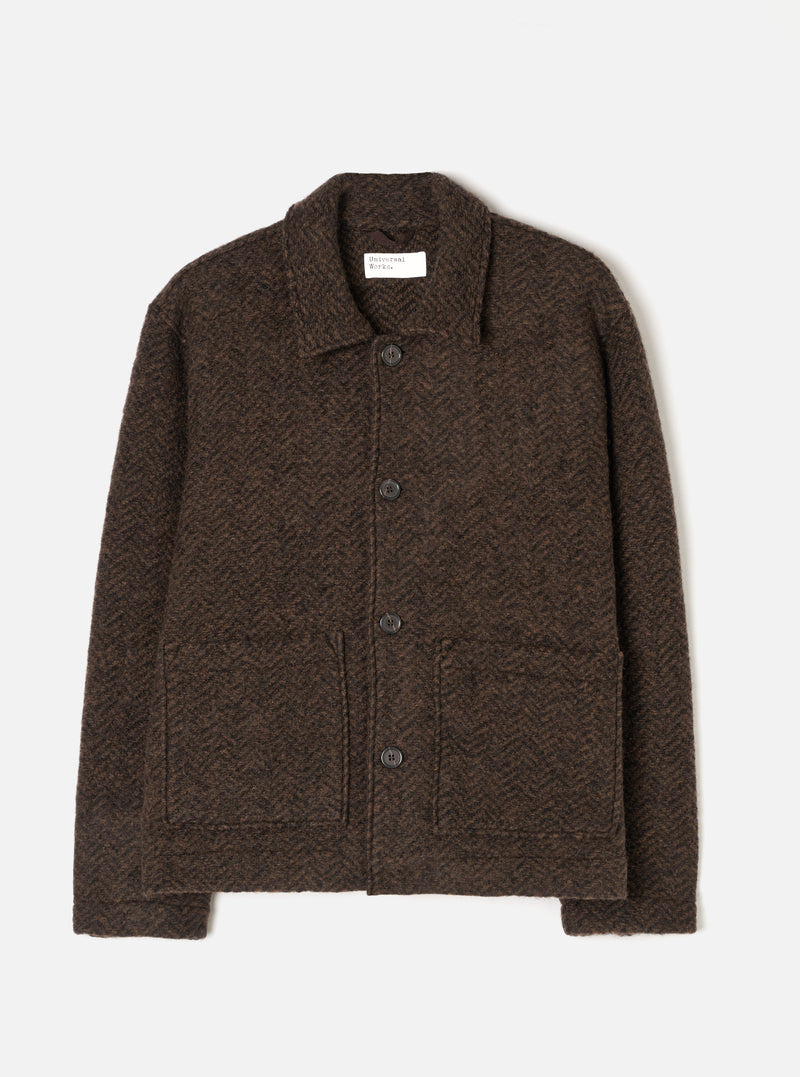 A front view of a model wearing the Brown Raven Fleece Rams Jacket in a minimalist studio setting. The image highlights the boxy silhouette, button-up front closure, collar, and large lower patch pockets.