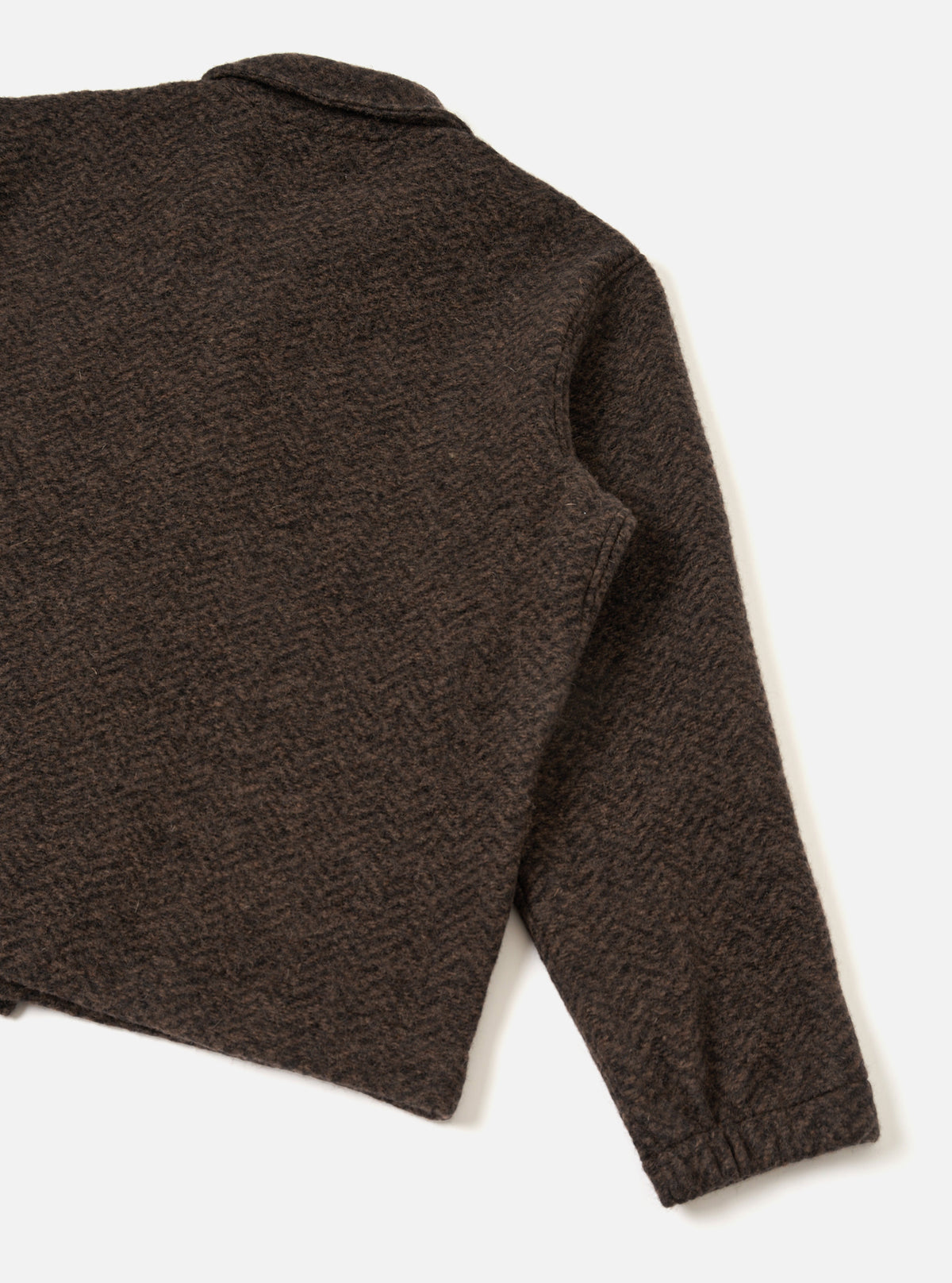 A back view of a model wearing the Brown Raven Fleece Rams Jacket against a plain studio background. The shot displays the dropped shoulder construction, straight hemline, and brown marl fleece texture.