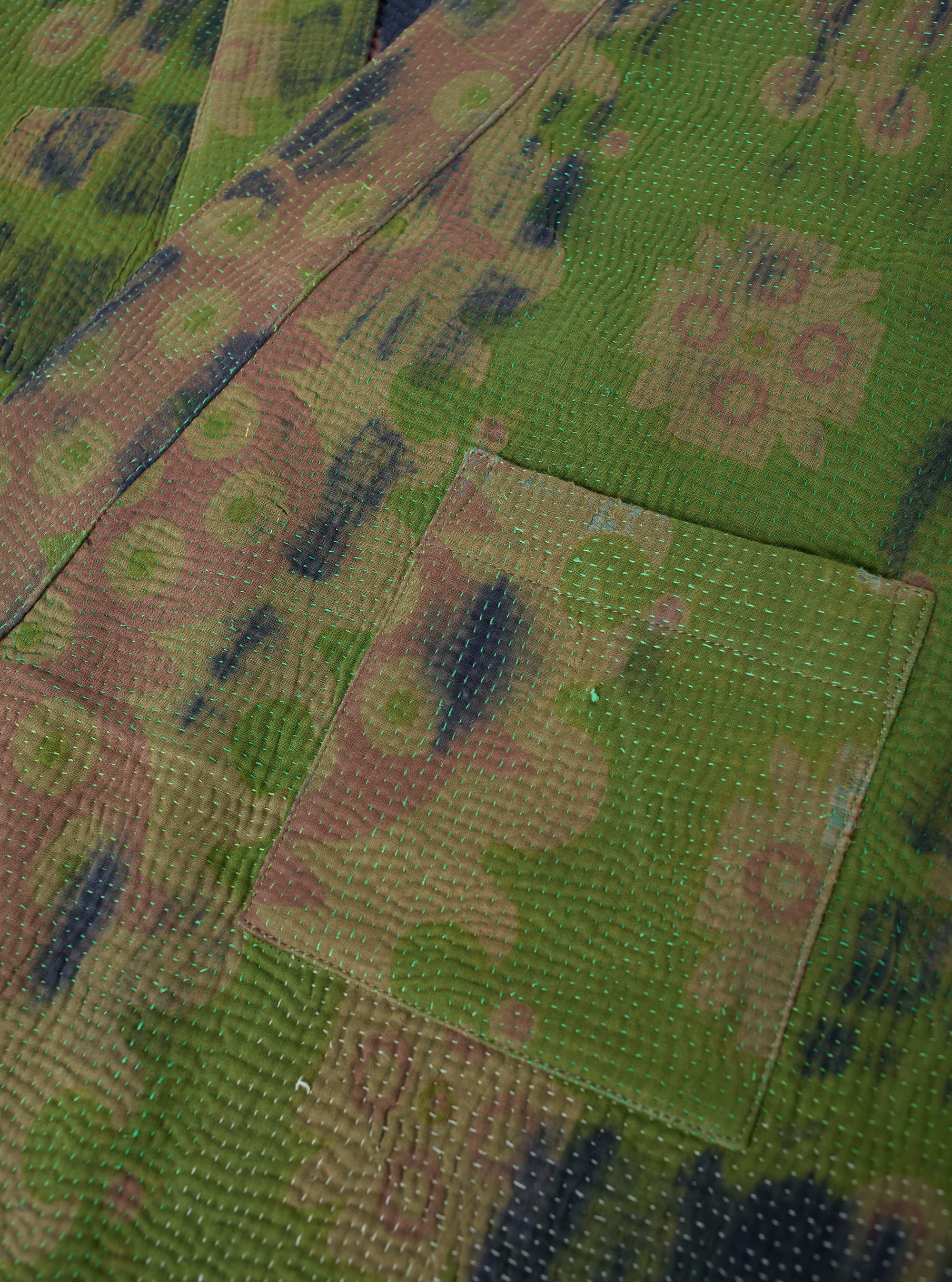 Close up of the Green Tie Dye #4 Kantha Kyoto Work Jacket - Large. The jacket has a green tie dye pattern with a pocket. The jacket is made of a quilted material.