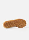 Close-up of the sole of a Novesta for Universal Works Off-White/White Leather German Army Trainer. The sole is a light brown rubber with a textured pattern. The background is a plain white.