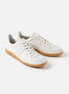 Studio shot of Novesta for Universal Works Off-White/White Leather German Army Trainer. The leather trainers have a gum sole and are on a white background.