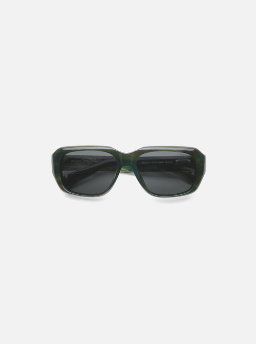 A. SOCIETY x Universal Works Green Aberdeen Sunglasses on a white surface. Green havana frame with dark lenses. 