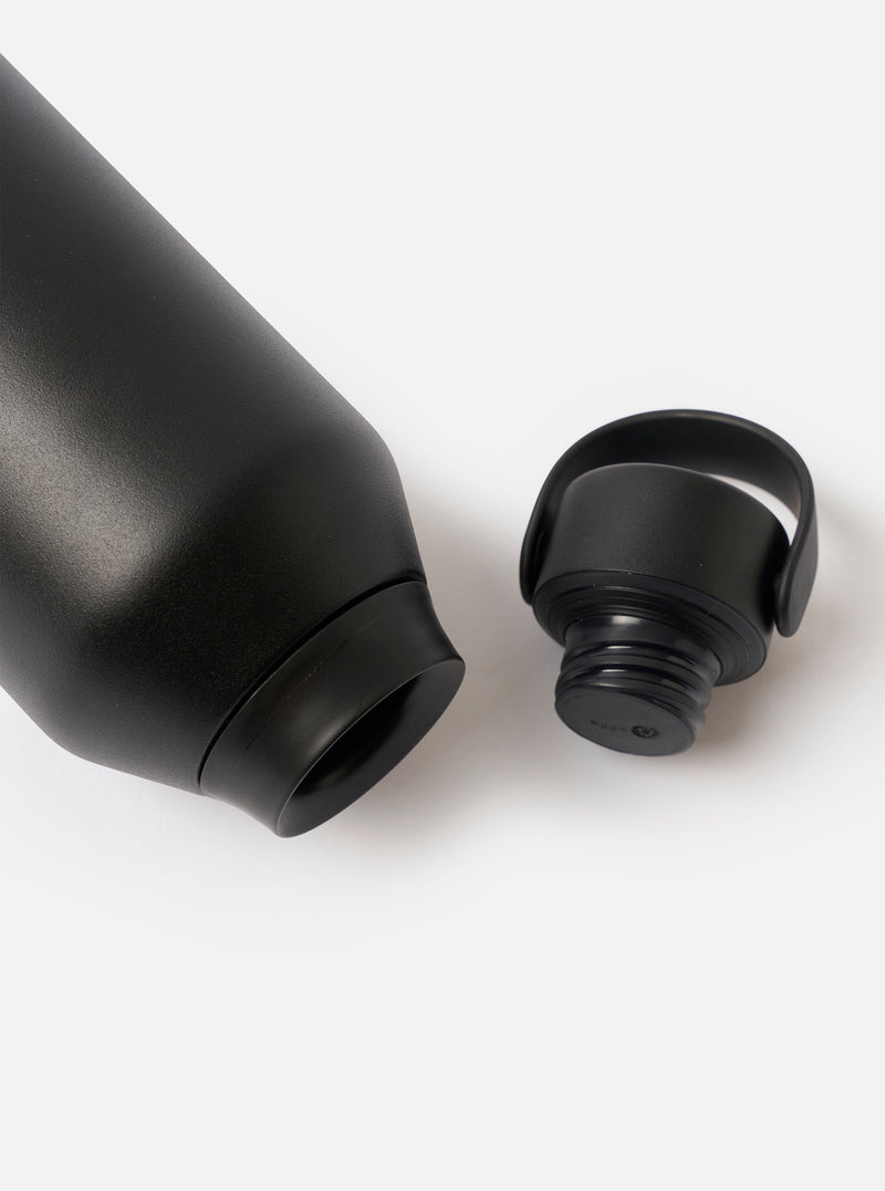 Angled view of the Chilly's x Universal Works Onyx Series 3 500ml Water Bottle set against a neutral white backdrop, focusing on the dark onyx finish and dual-branded logo detailing.