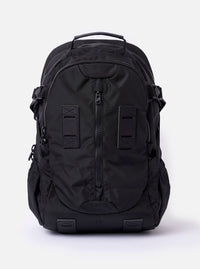 The F/CE. Black Recycled Nylon 420 re/cor Travel Backpack is shown as a flat lay against a white background. The backpack features a sleek, slightly shiny black finish with multiple functional front compartments, a top carry handle, and adjustable shoulder straps. The design includes various webbing loops and a prominent front pocket with vertical zip closures.