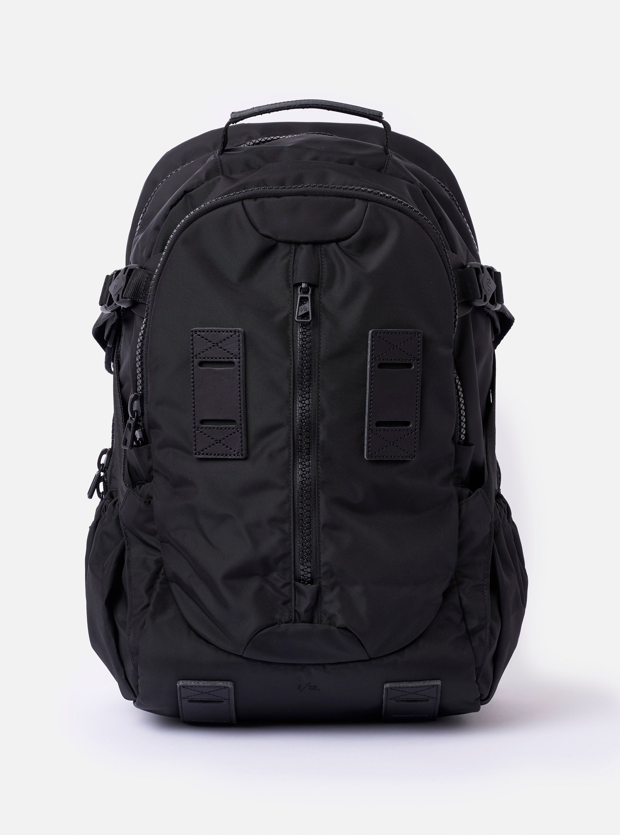 The F/CE. Black Recycled Nylon 420 re/cor Travel Backpack is shown as a flat lay against a white background. The backpack features a sleek, slightly shiny black finish with multiple functional front compartments, a top carry handle, and adjustable shoulder straps. The design includes various webbing loops and a prominent front pocket with vertical zip closures.