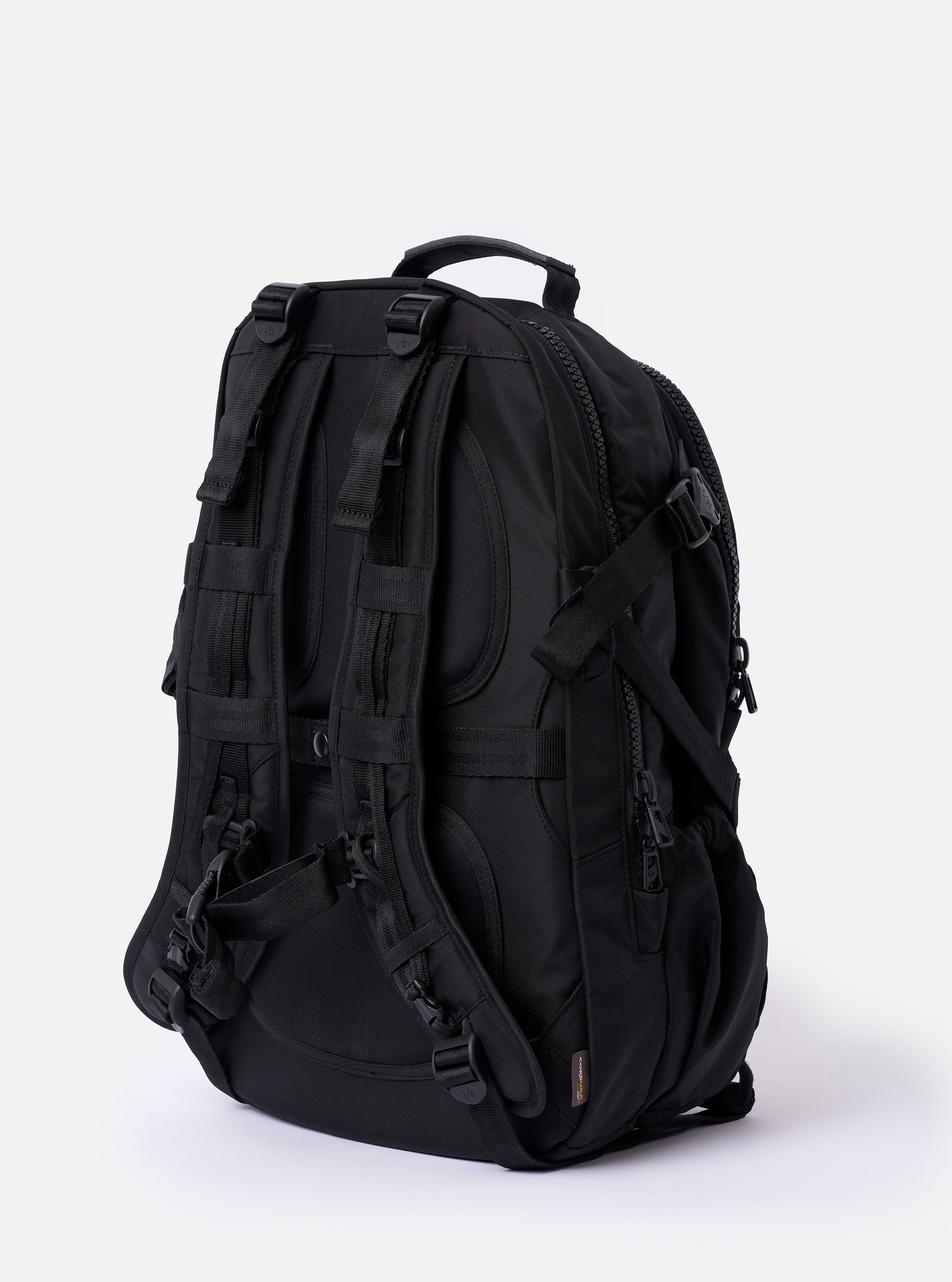 The F/CE.® Black Recycled Nylon 420 re/cor Travel Backpack is shown from a rear angle against a plain white background. The image highlights the ergonomic shoulder straps, a padded back panel made of technical mesh, and a top haul handle. A small brand label is visible on one strap.