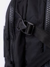 The F/CE.® Black Recycled Nylon 420 re/cor Travel Backpack is shown from a rear angle against a plain white background. The image highlights the padded, ergonomic shoulder straps with the Mounting T System, a mesh-padded back panel for comfort, and a top carry handle. The backpack is made from a sleek, black recycled nylon fabric.