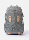 The F/CE.® Foliage Green Recycled Nylon 420 re/cor Travel Backpack is shown from a front angle against a plain white background. The backpack features a multi-pocket design with a prominent front gadget pocket, adjustable shoulder straps equipped with a mounting system, and a top haul handle. The foliage green recycled nylon fabric has a subtle sheen, and black hardware and buckles provide a functional contrast.
