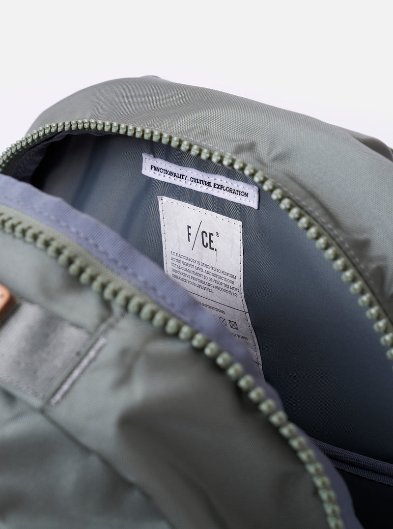 The F/CE. Foliage Green Recycled Nylon 420 re/cor Travel Backpack is shown in a detail view, focusing on the padded neoprene back panel and the ergonomic shoulder straps. The image highlights the technical mesh and high-specification materials used for comfort. The backpack is presented against a plain white background with no model or mannequin present.