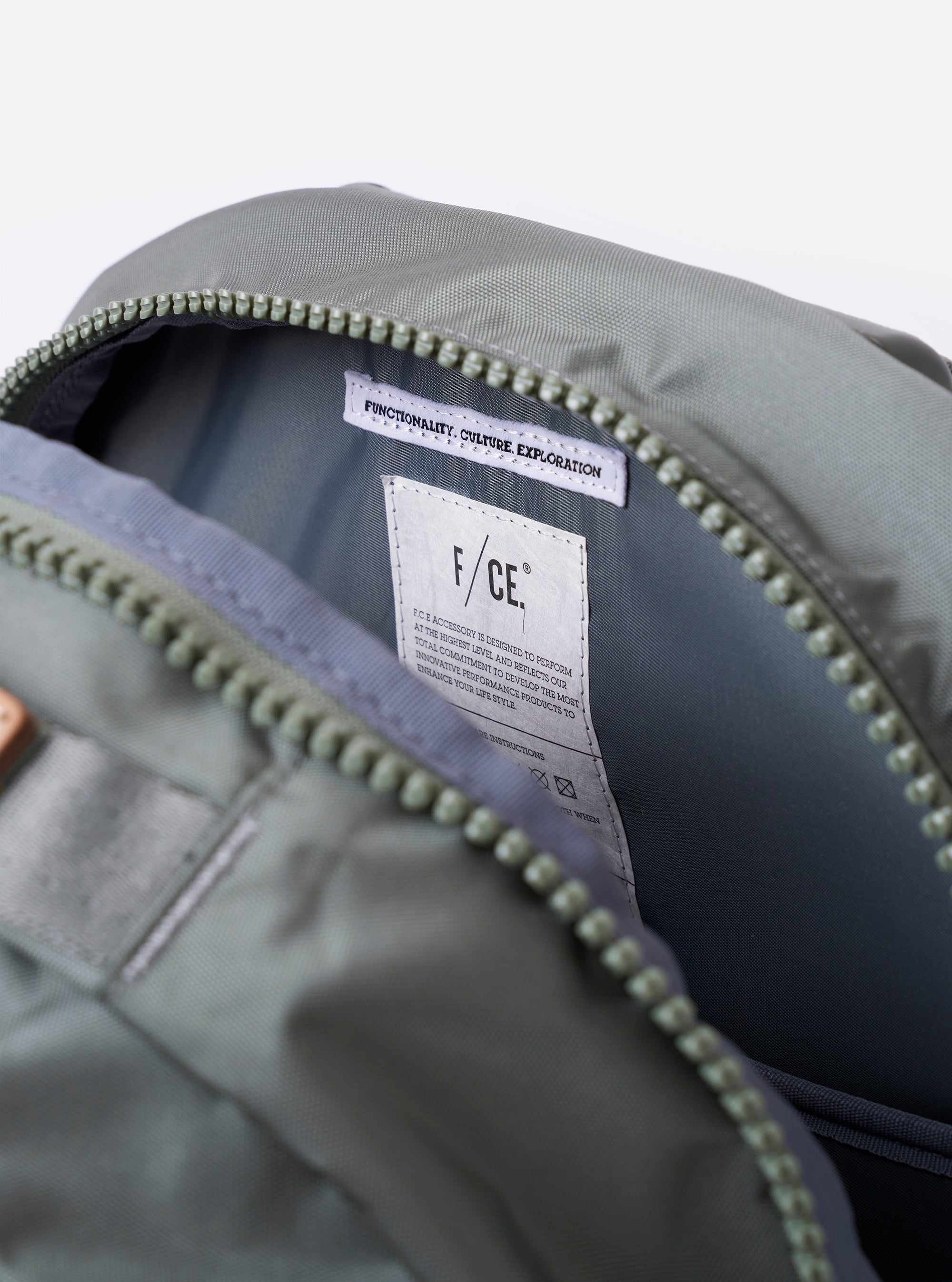 The F/CE. Foliage Green Recycled Nylon 420 re/cor Travel Backpack is shown in a detail view, focusing on the padded neoprene back panel and the ergonomic shoulder straps. The image highlights the technical mesh and high-specification materials used for comfort. The backpack is presented against a plain white background with no model or mannequin present.