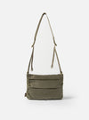 The F/CE.® Sage Green 420 re/cor Sacoche bag in sage green fabric with a strap, shot against a white background. The bag has a rectangular shape with three horizontal zippered compartments.