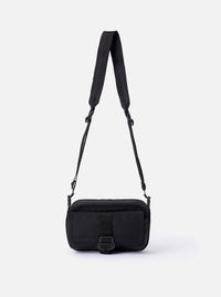 The F/CE. Black Recycled Nylon 420 re/cor Holiday Sacoche is shown as a flat lay against a white background. The small black travel bag features a main zipped compartment, a front zip pocket, and an adjustable shoulder strap with a plastic buckle. A white F/CE. brand label is stitched on the front.