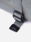 The F/CE.® Foliage Green Recycled Nylon 420 re/cor Holiday Sacoche is shown from a rear angle as a flat lay against a plain white background. The image highlights the adjustable black shoulder strap attached with plastic hardware and a small zippered pocket on the back. The foliage green recycled nylon fabric has a smooth, technical appearance.