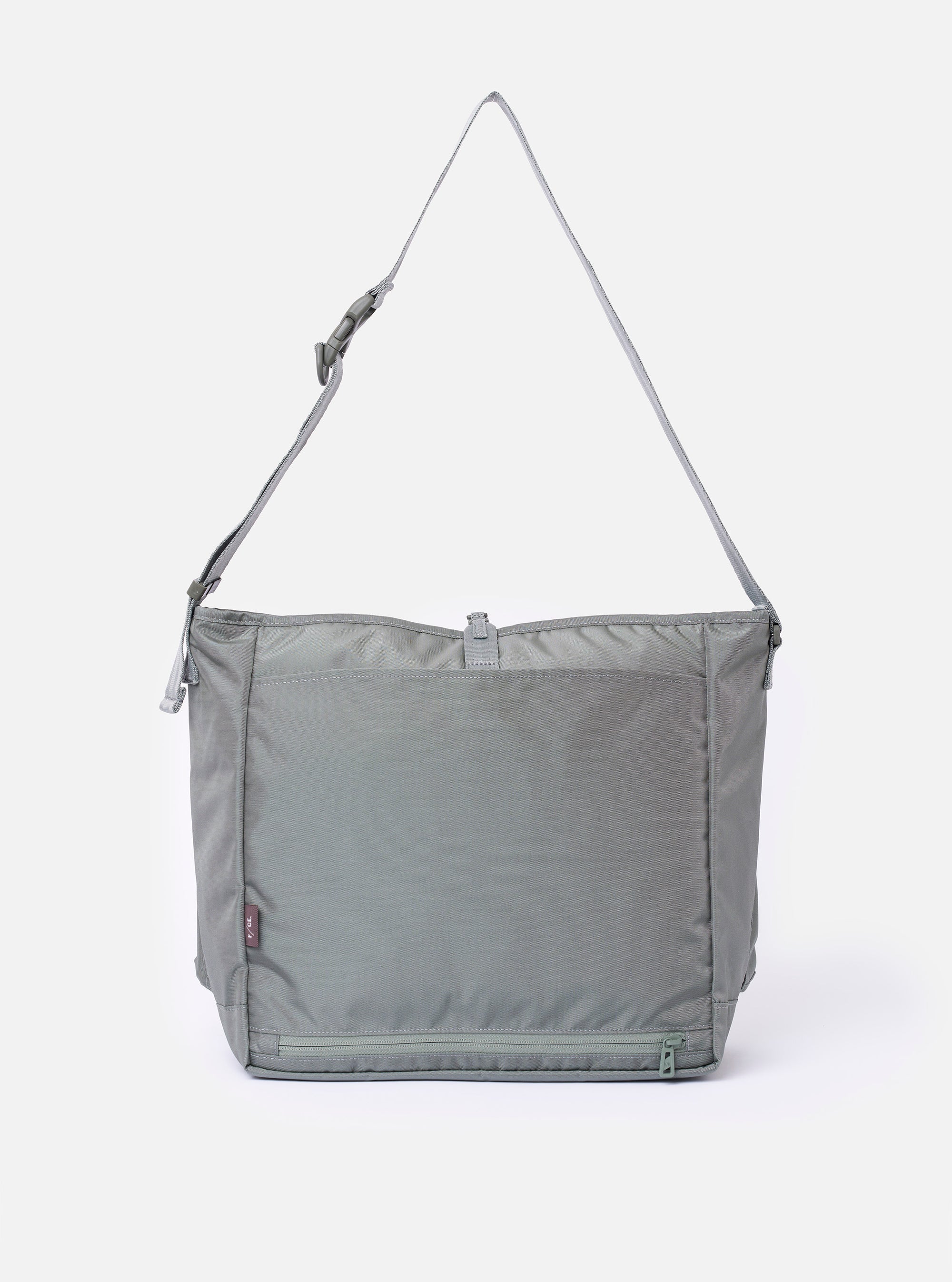 The F/CE.® Foliage Green Recycled Nylon 420 re/cor Courier Shoulder Bag is shown from a rear angle as a flat lay against a plain white background. The image highlights the adjustable messenger-style shoulder strap with a one-touch buckle and the smooth foliage green recycled nylon fabric.
