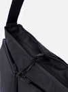 The F/CE.® Black Recycled Nylon 420 re/cor Courier Shoulder Bag is shown from a rear three-quarter angle as a flat lay against a plain white background. The image highlights the adjustable padded shoulder strap with a one-touch plastic buckle and the breathable mesh panel on the back of the bag. The black recycled nylon fabric has a smooth, technical appearance with visible tonal stitching.