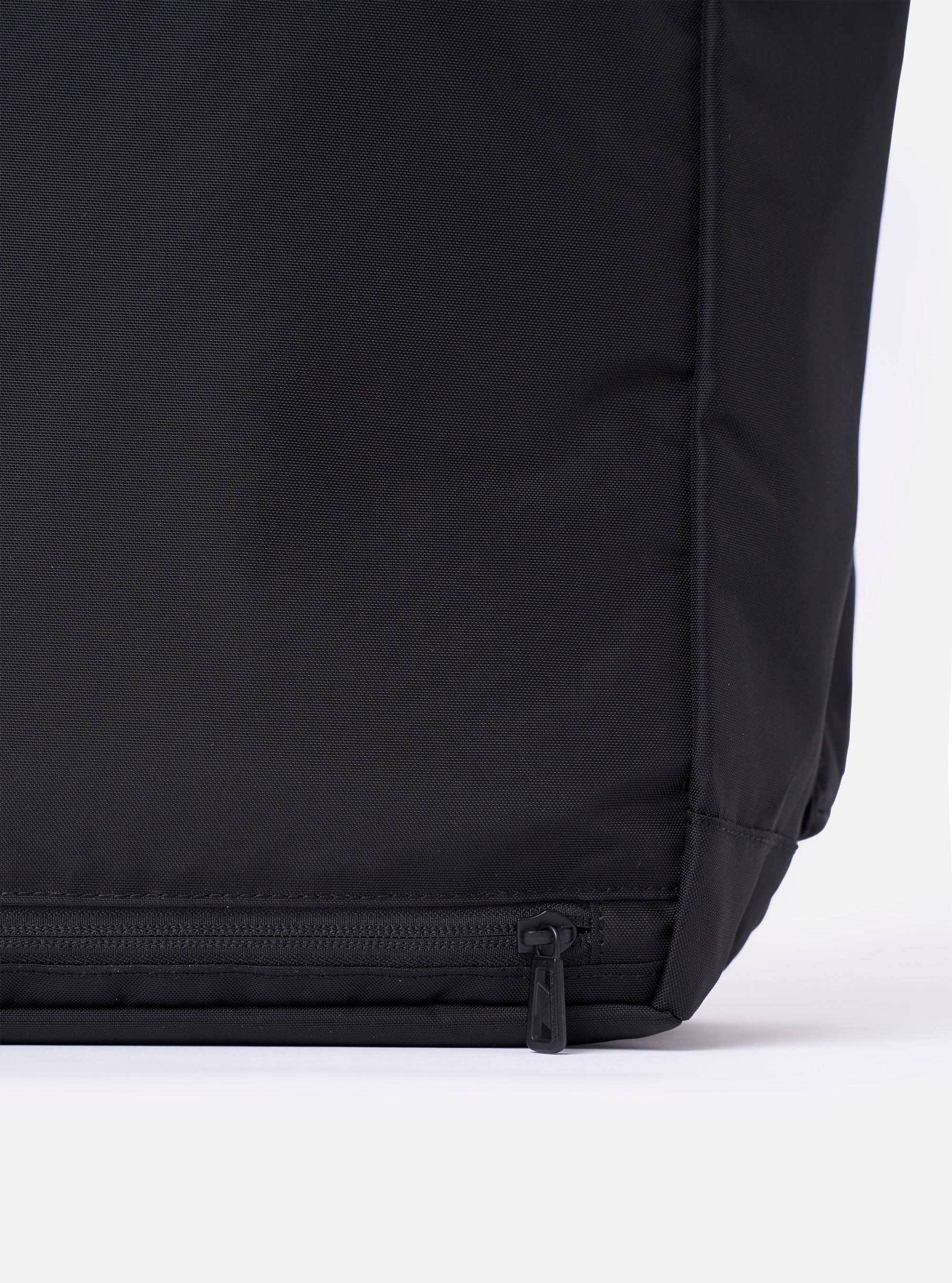 The F/CE.® Black Recycled Nylon 420 re/cor Courier Shoulder Bag is shown from a rear three-quarter angle as a flat lay against a plain white background. The image highlights the adjustable messenger-style shoulder strap with a one-touch mechanism and the padded back panel. The black recycled nylon fabric has a smooth, technical finish.