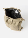 Open F/CE.® Sage Green Recycled Twill 3-Way Helmet Bag on a white background. The bag's interior is black with multiple pockets and a white label. The bag is made of a sage green twill material.