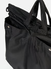 Close-up of the F/CE.® Black Recycled Twill 3-Way Helmet Bag. The black twill material is visible, along with straps and silver button details. Shot against a white background.