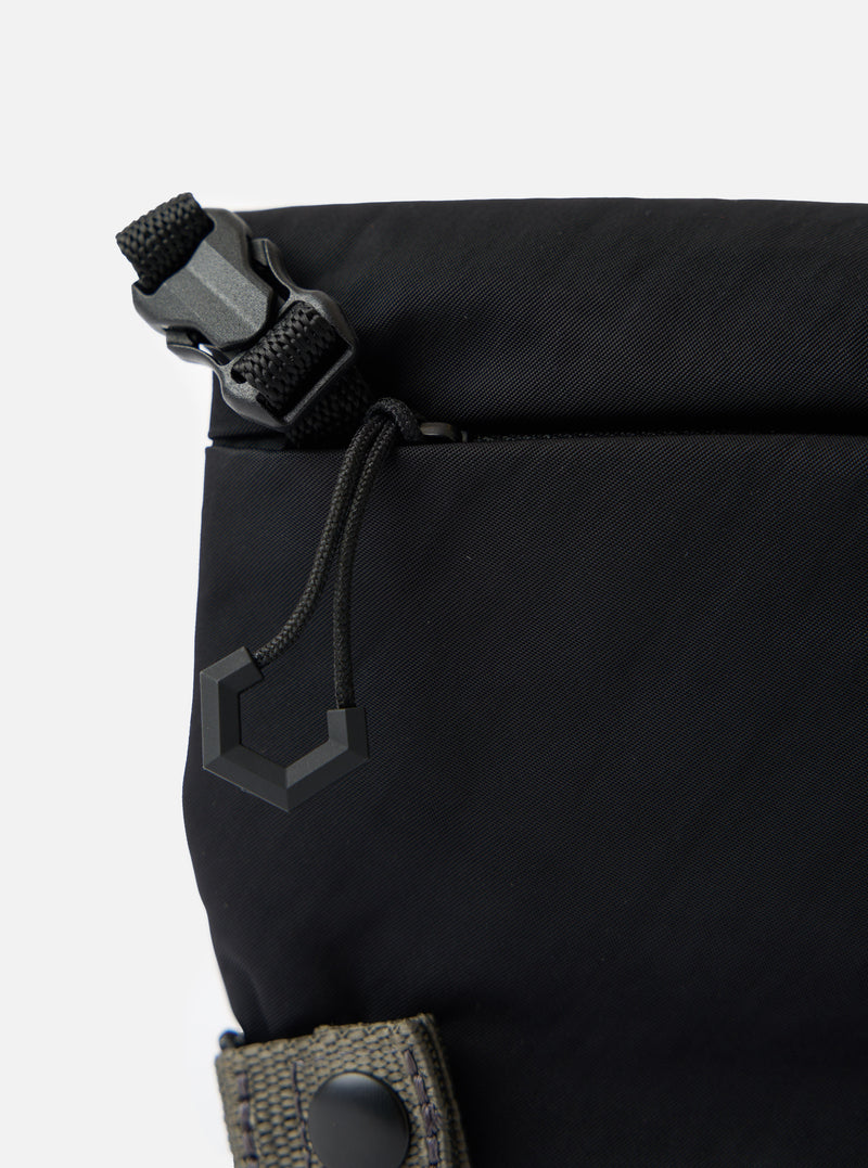 Close-up of the F/CE.® Black Nylon Textured Twill Drawstring Sacoche. Shows the black textured nylon, drawstring detail, and buckle against a white background.