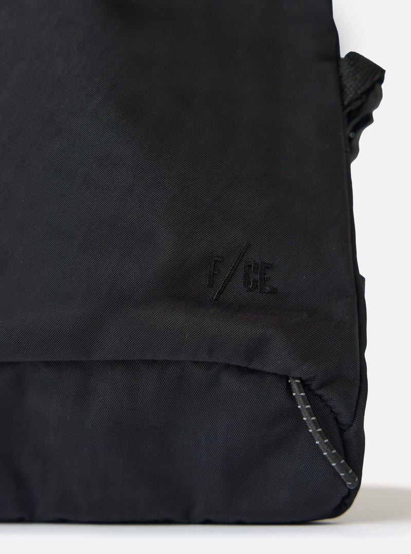 Close-up of the F/CE.® Black Nylon Textured Twill Drawstring Sacoche on a white surface. Shows the textured nylon, drawstring detail, and subtle branding.