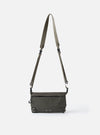 The F/CE.® Charcoal Nylon Textured Twill Drawstring Sacoche bag in charcoal, hanging against a white background. The bag features a nylon twill texture and a drawstring closure.